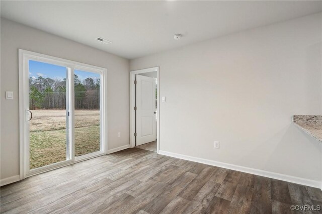 interior space featuring visible vents, baseboards, and wood finished floors