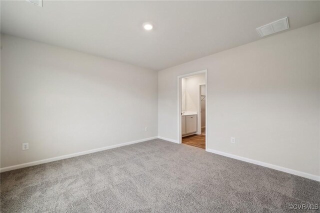 carpeted spare room with baseboards, visible vents, and recessed lighting