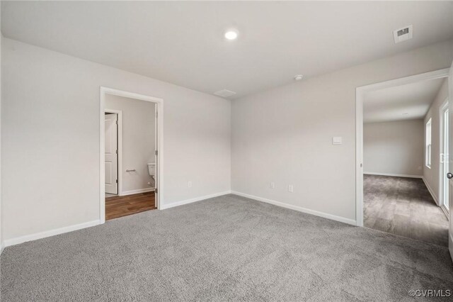 carpeted spare room with baseboards and visible vents