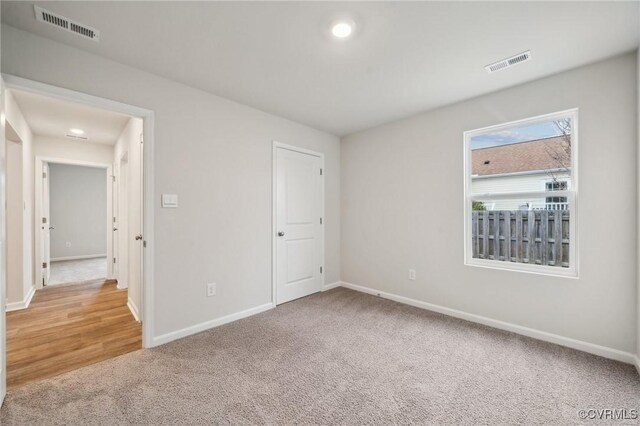 unfurnished bedroom with baseboards, visible vents, and carpet