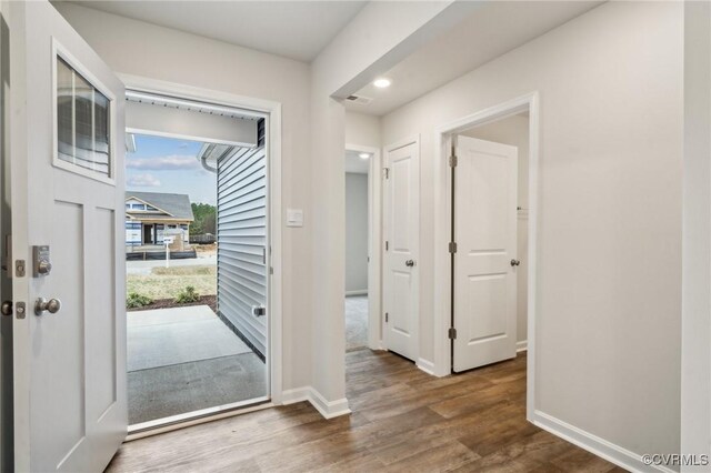 foyer entrance with baseboards, wood finished floors, and recessed lighting