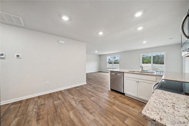 kitchen featuring recessed lighting, dishwasher, visible vents, wood finished floors, and a sink