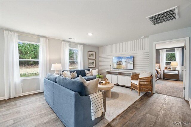 living room featuring wood finished floors, visible vents, and plenty of natural light