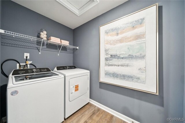 laundry room featuring light wood-style floors, washer and clothes dryer, baseboards, and laundry area