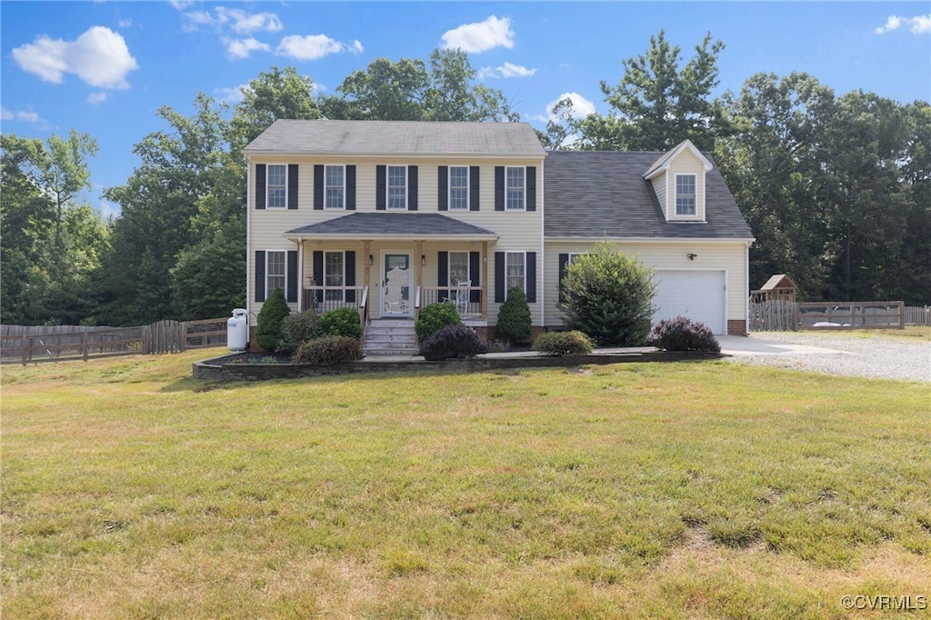 colonial home with an attached garage, fence, a porch, a front yard, and gravel driveway