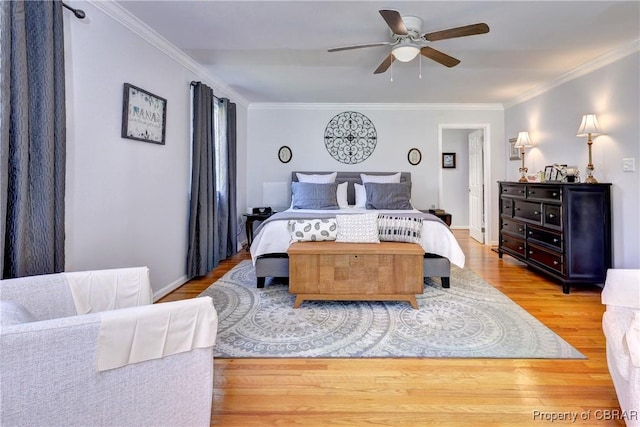 bedroom featuring baseboards, a ceiling fan, wood finished floors, and crown molding