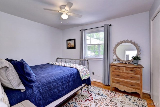 bedroom with baseboards, a ceiling fan, and wood finished floors