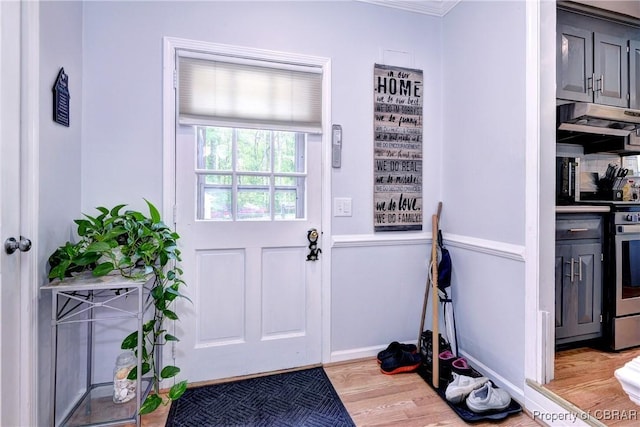 doorway to outside featuring baseboards and wood finished floors