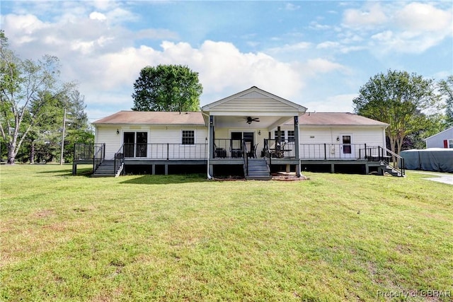 back of property featuring stairway, ceiling fan, a lawn, and a wooden deck