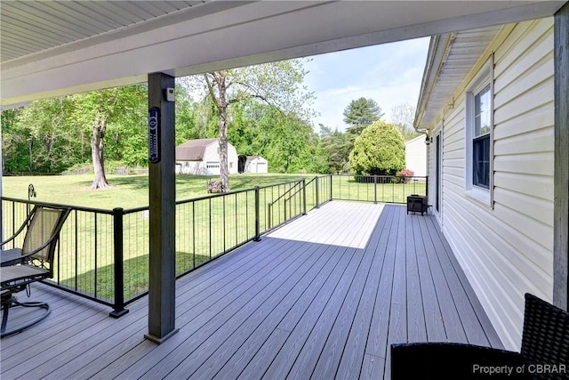 wooden deck featuring an outdoor structure and a yard