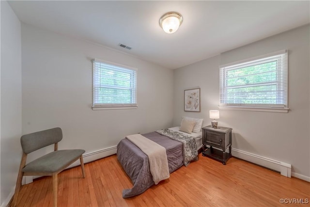 8000 N Courthouse Rd, New Kent, VA 23124 - bedroom featuring visible vents, wood finished floors, multiple windows, and a baseboard radiator