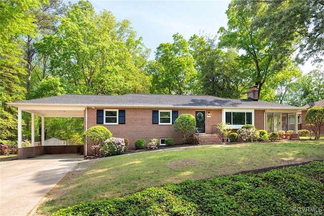 ranch-style home with brick siding, a chimney, a front lawn, and concrete driveway