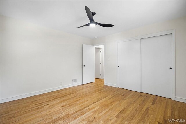 unfurnished bedroom with light wood-type flooring, baseboards, visible vents, a closet, and ceiling fan