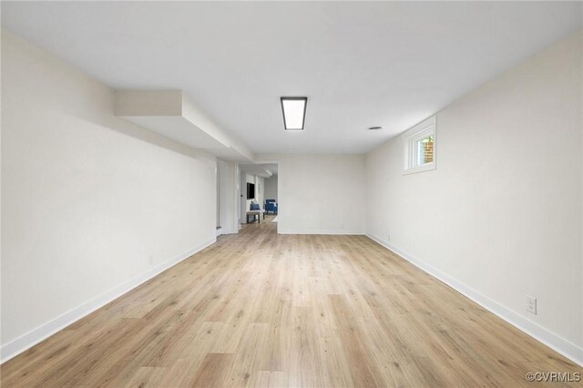 below grade area with light wood-style flooring and baseboards
