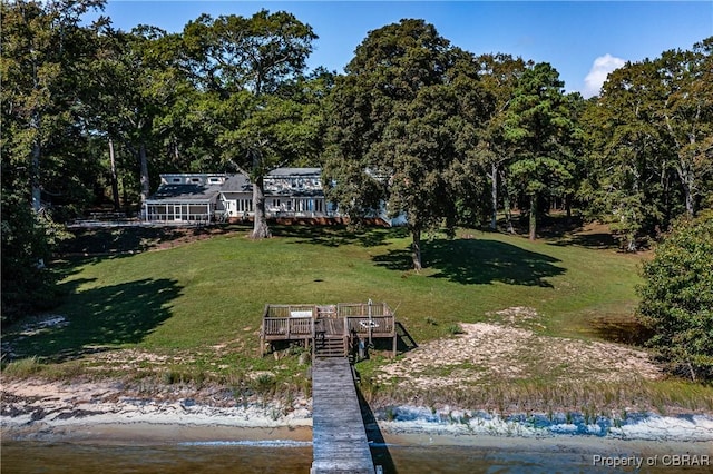 dock area featuring a lawn and a deck with water view