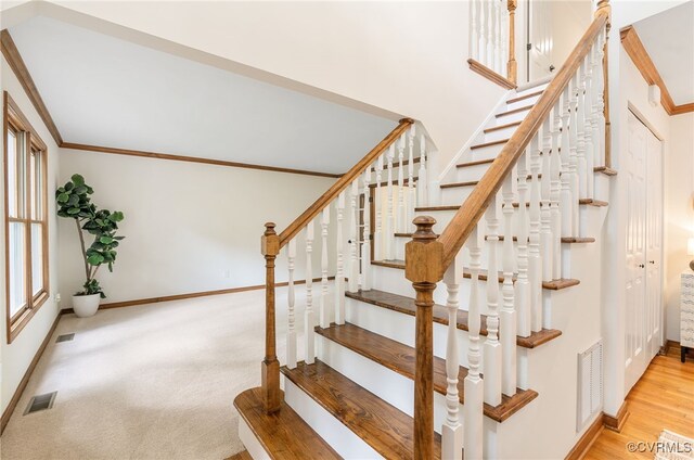 stairway with crown molding, baseboards, and wood finished floors