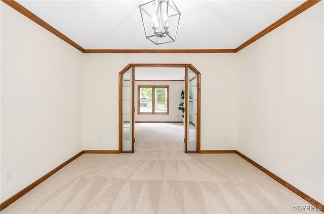 unfurnished room with ornamental molding, light carpet, baseboards, and a chandelier