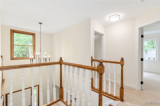 stairs featuring carpet, baseboards, and a chandelier