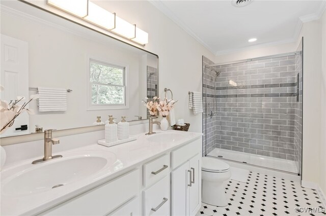full bathroom featuring toilet, a tile shower, crown molding, double vanity, and tile patterned floors