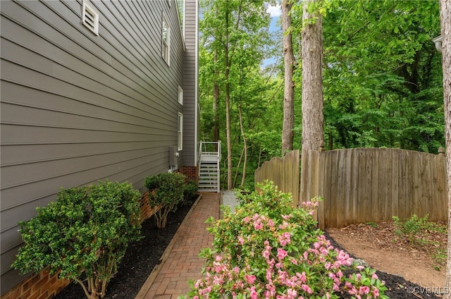 view of side of property with fence and stairs