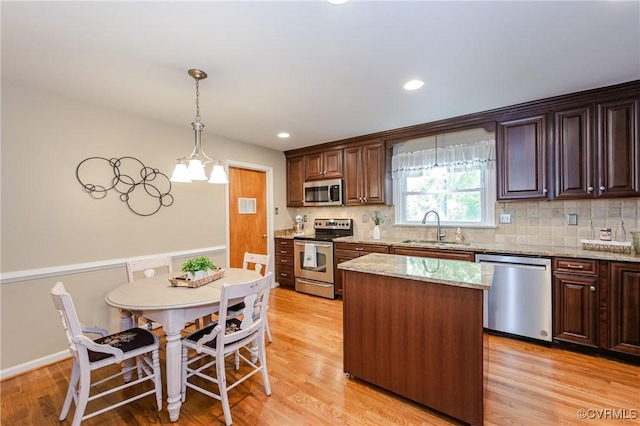 kitchen featuring a sink, appliances with stainless steel finishes, tasteful backsplash, and light wood-type flooring