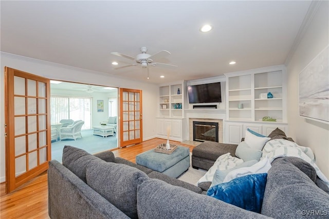 living area featuring crown molding, a ceiling fan, recessed lighting, and light wood-style flooring