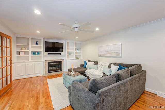living room with ceiling fan, a fireplace, light wood-style flooring, recessed lighting, and visible vents