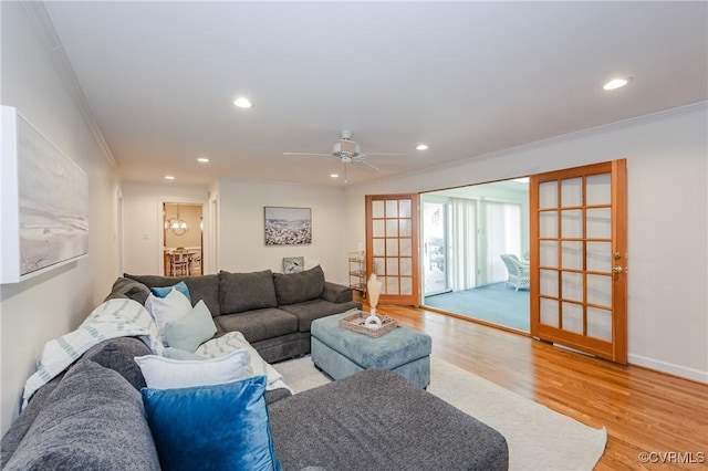 living area with a ceiling fan, crown molding, baseboards, light wood-style floors, and recessed lighting