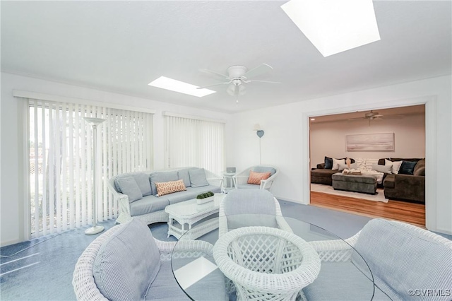living room with a skylight and ceiling fan