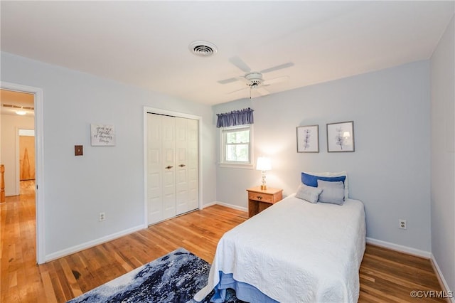 bedroom featuring baseboards, wood finished floors, and a closet