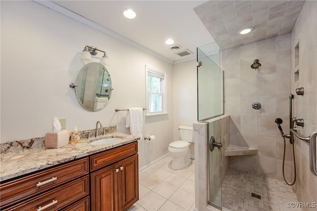 full bathroom featuring crown molding, vanity, toilet, and a shower stall