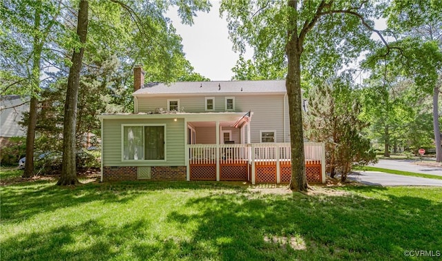 back of house featuring a wooden deck, a yard, and a chimney