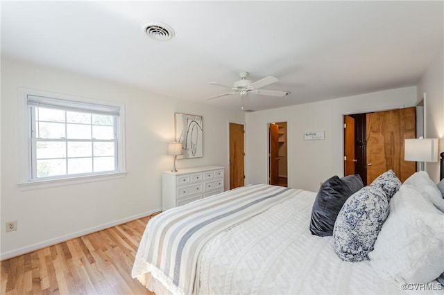 bedroom with visible vents, light wood-style flooring, ceiling fan, and baseboards
