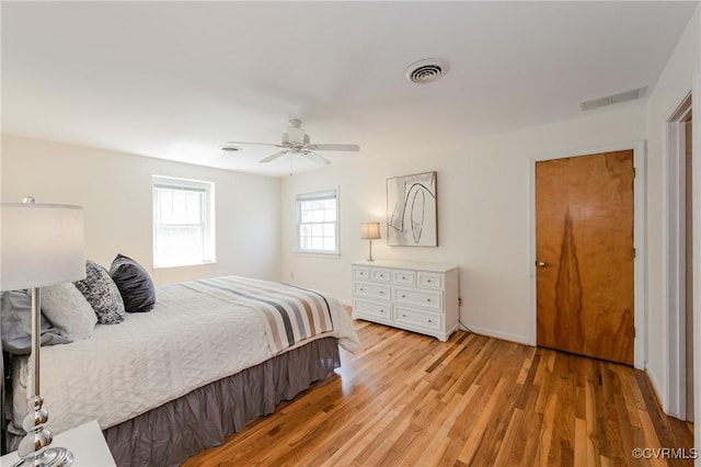 bedroom featuring visible vents, a ceiling fan, and light wood-style floors