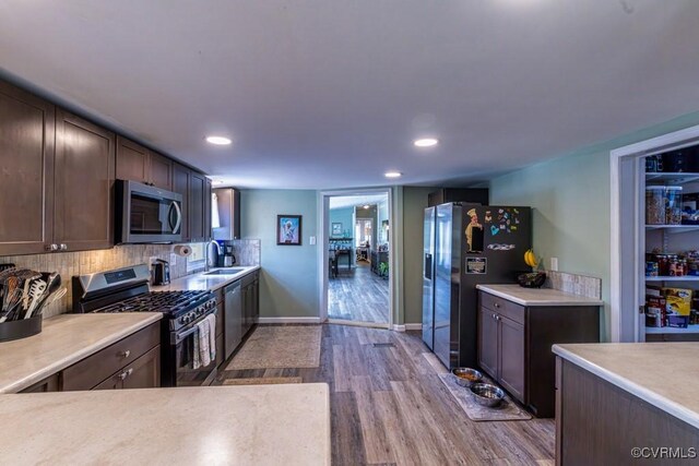 kitchen with recessed lighting, appliances with stainless steel finishes, wood finished floors, and light countertops