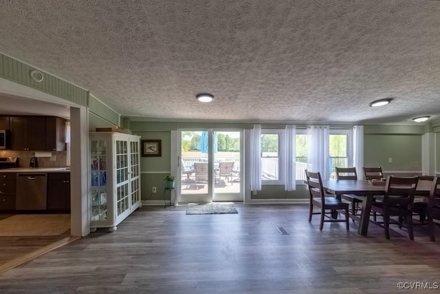 dining room featuring baseboards, a textured ceiling, and dark wood-type flooring