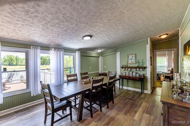 dining area featuring ornamental molding, wood finished floors, and a textured ceiling