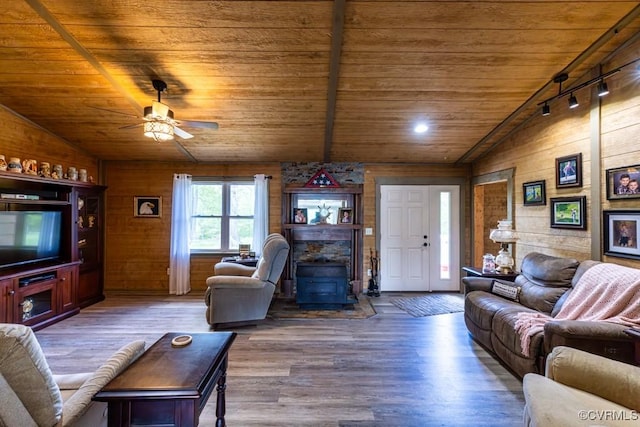 living area with lofted ceiling, a ceiling fan, wood finished floors, wood ceiling, and wooden walls