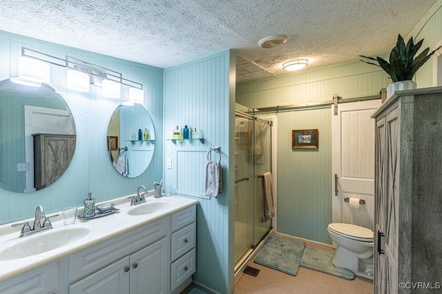 full bath with double vanity, a shower stall, toilet, and a sink
