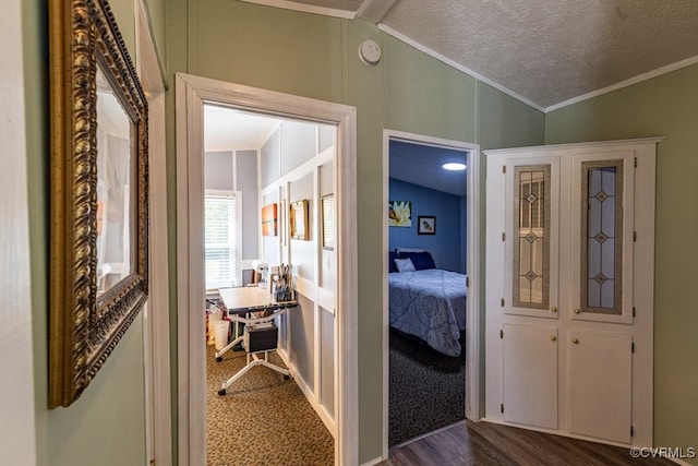 corridor featuring vaulted ceiling, crown molding, and dark wood-style flooring