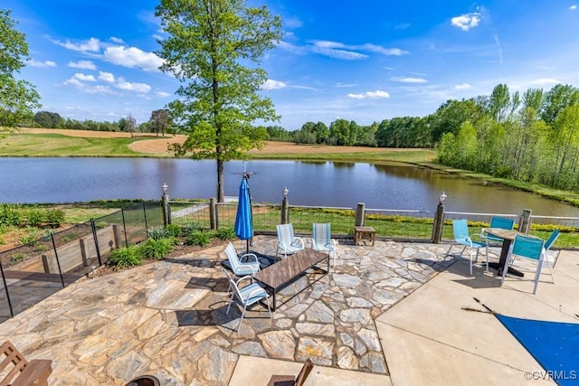 view of patio featuring fence and a water view