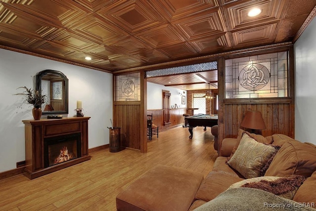 living area with an ornate ceiling, light wood finished floors, wooden walls, and billiards