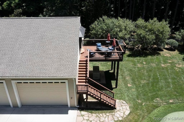 view of property exterior with concrete driveway, a shingled roof, a yard, a wooden deck, and stairs