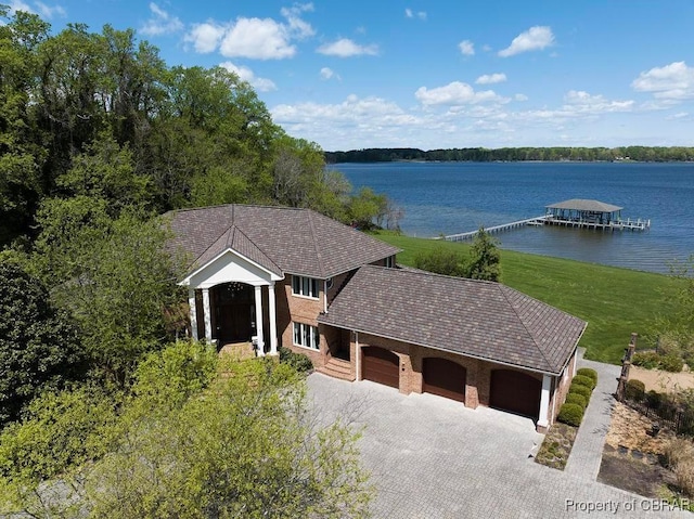 exterior space featuring an attached garage, a water view, and driveway