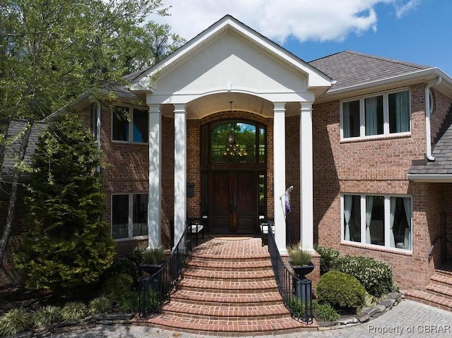 entrance to property featuring brick siding