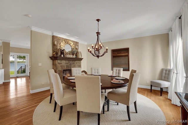 dining space with light wood-style flooring, baseboards, a chandelier, and ornamental molding