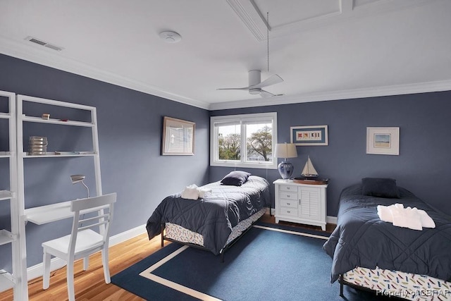bedroom with wood finished floors, visible vents, a ceiling fan, ornamental molding, and baseboards