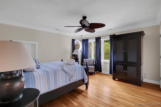 bedroom with baseboards, ornamental molding, light wood-style floors, and visible vents