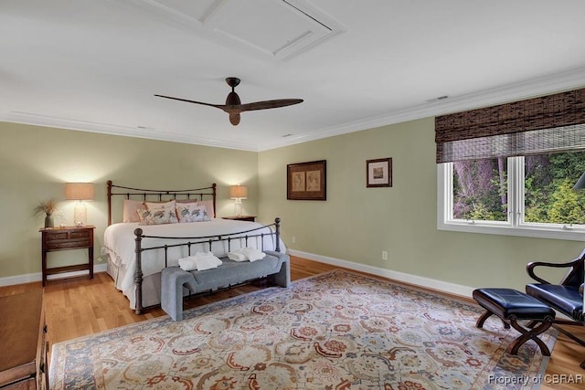 bedroom featuring a ceiling fan, crown molding, wood finished floors, baseboards, and visible vents