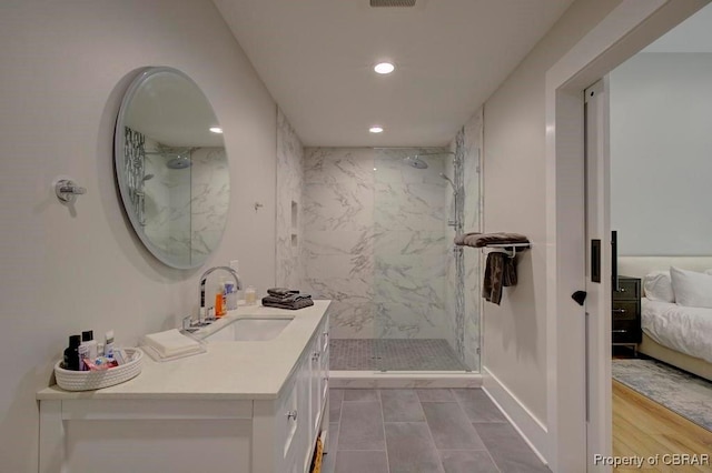 full bathroom with recessed lighting, vanity, and a marble finish shower